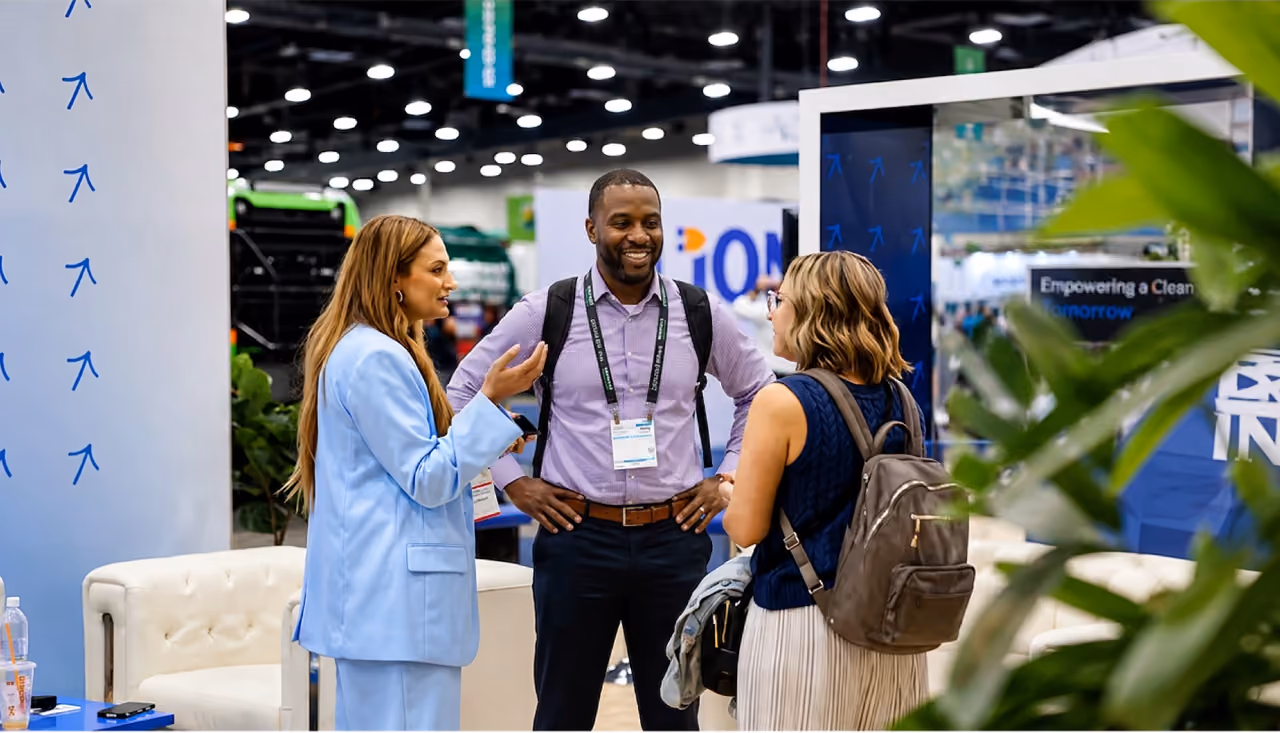 Three Waste Harmonics Keter colleagues talking together at the company trade show booth