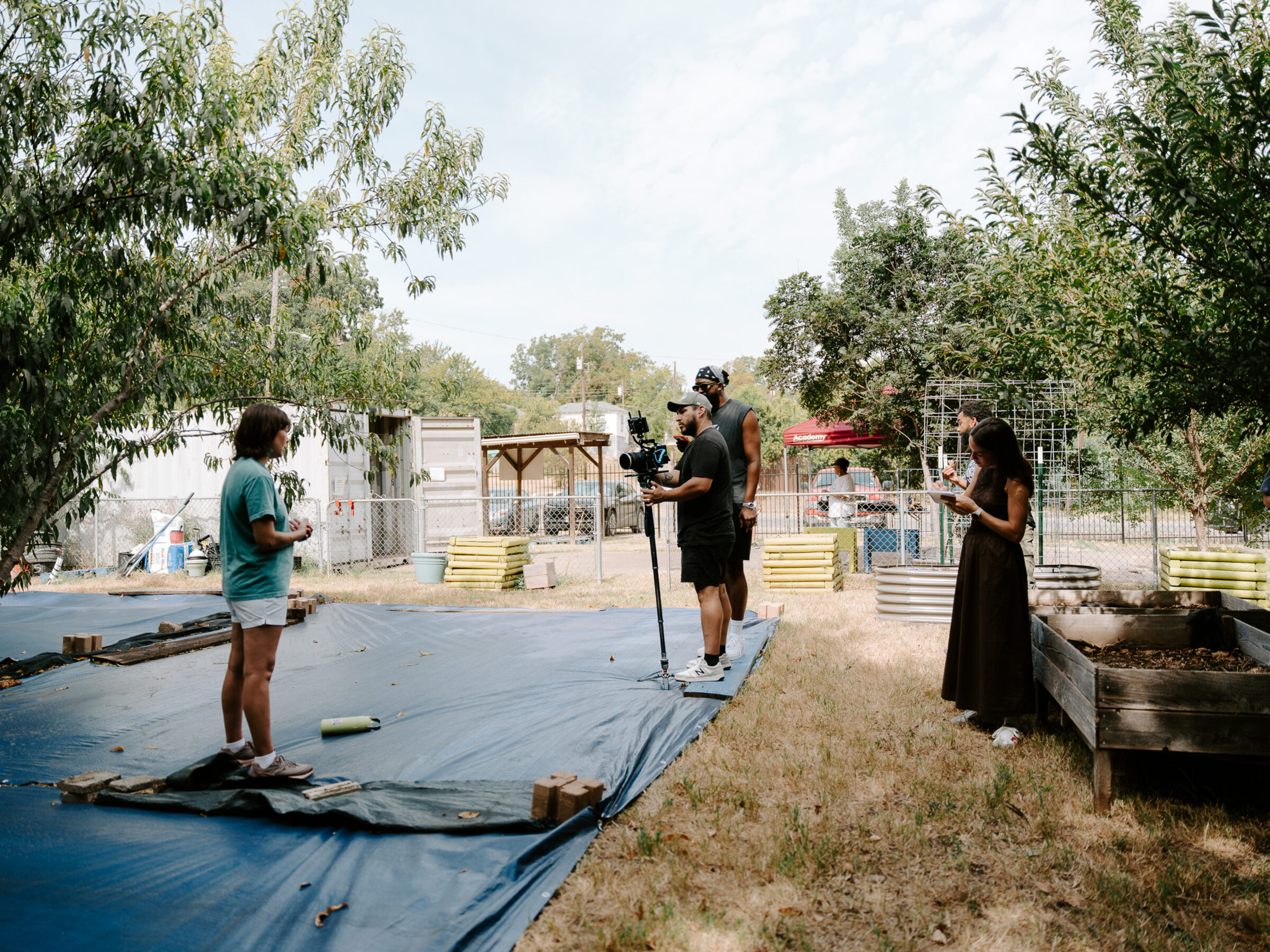 A film crew records an interview across the raised beds at the Oak Cliff Veggie Project's 10th Street Community Garden in Dallas