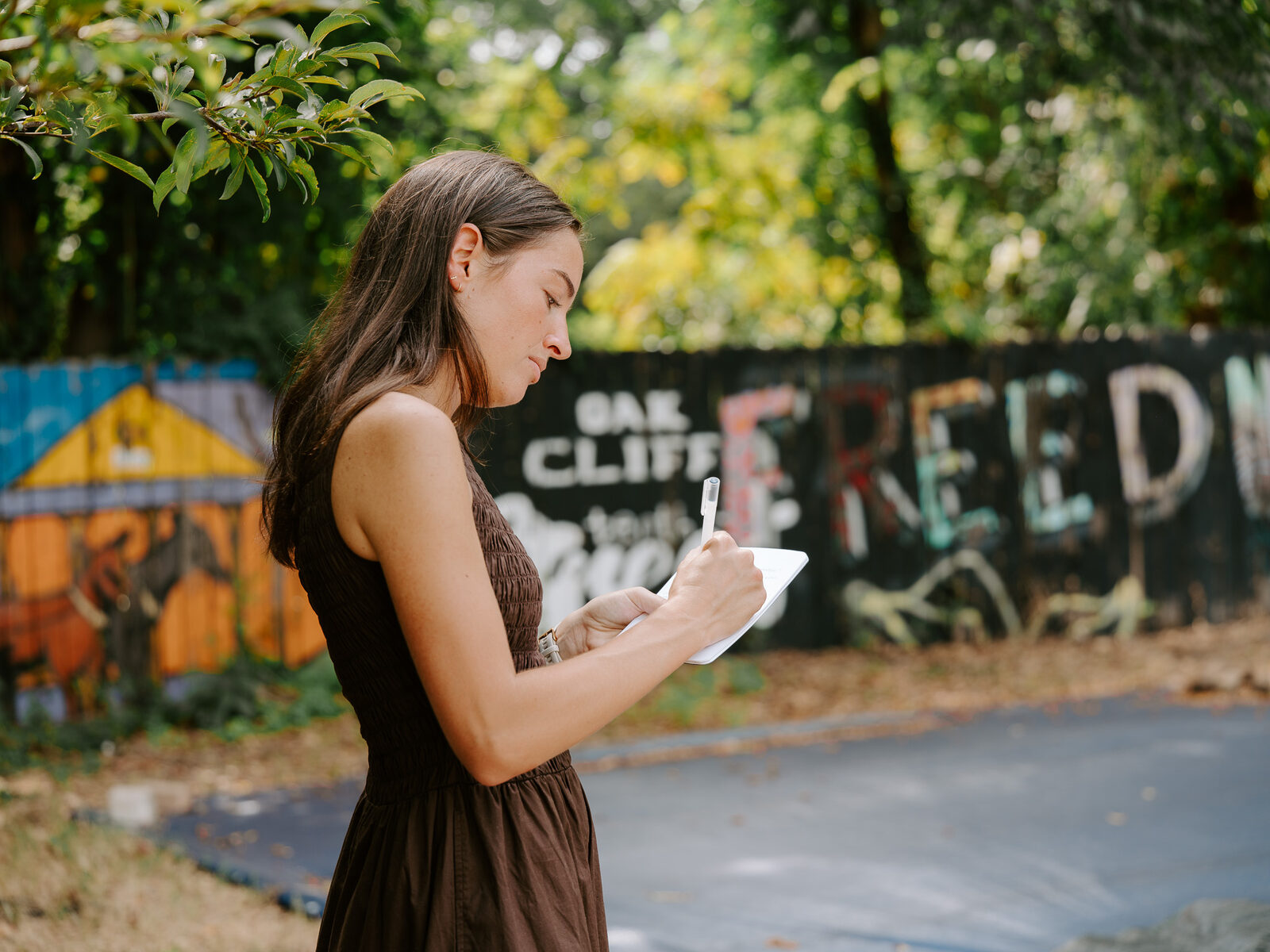 A Good Word Agency strategist reviews campaign notes in front of the Tenth Street Freedman's Town mural