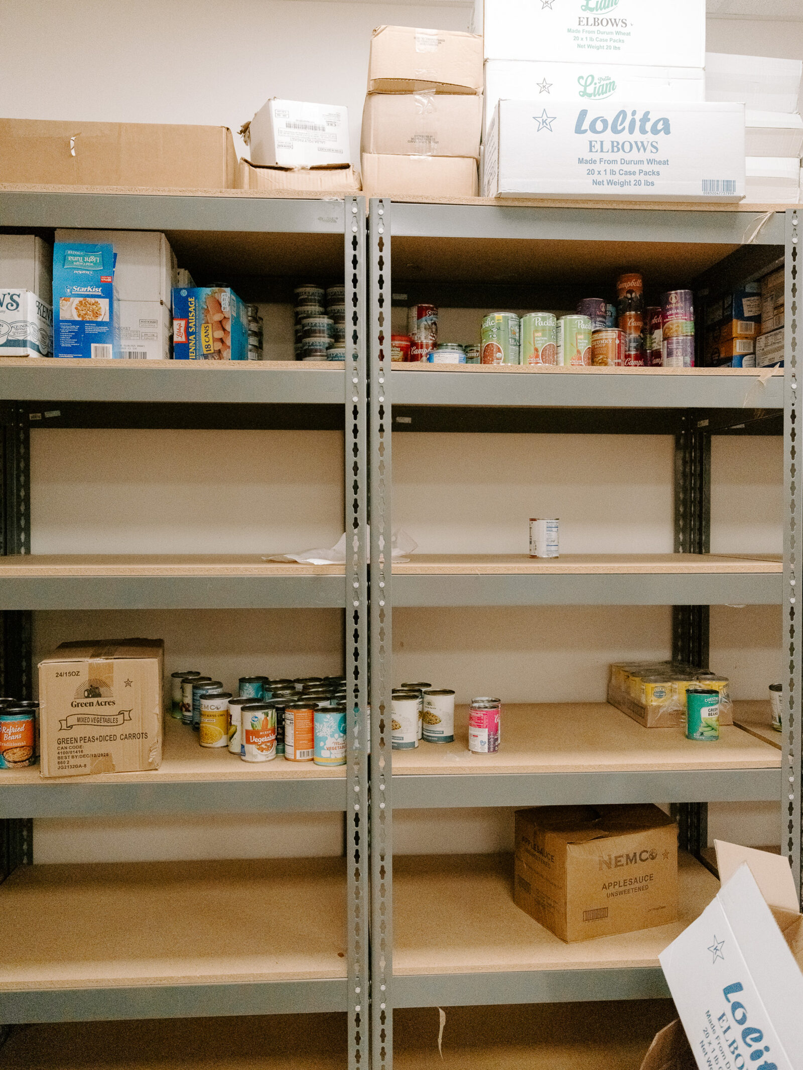Near-empty shelving at the Oak Cliff Veggie Project food pantry, with a few canned goods remaining
