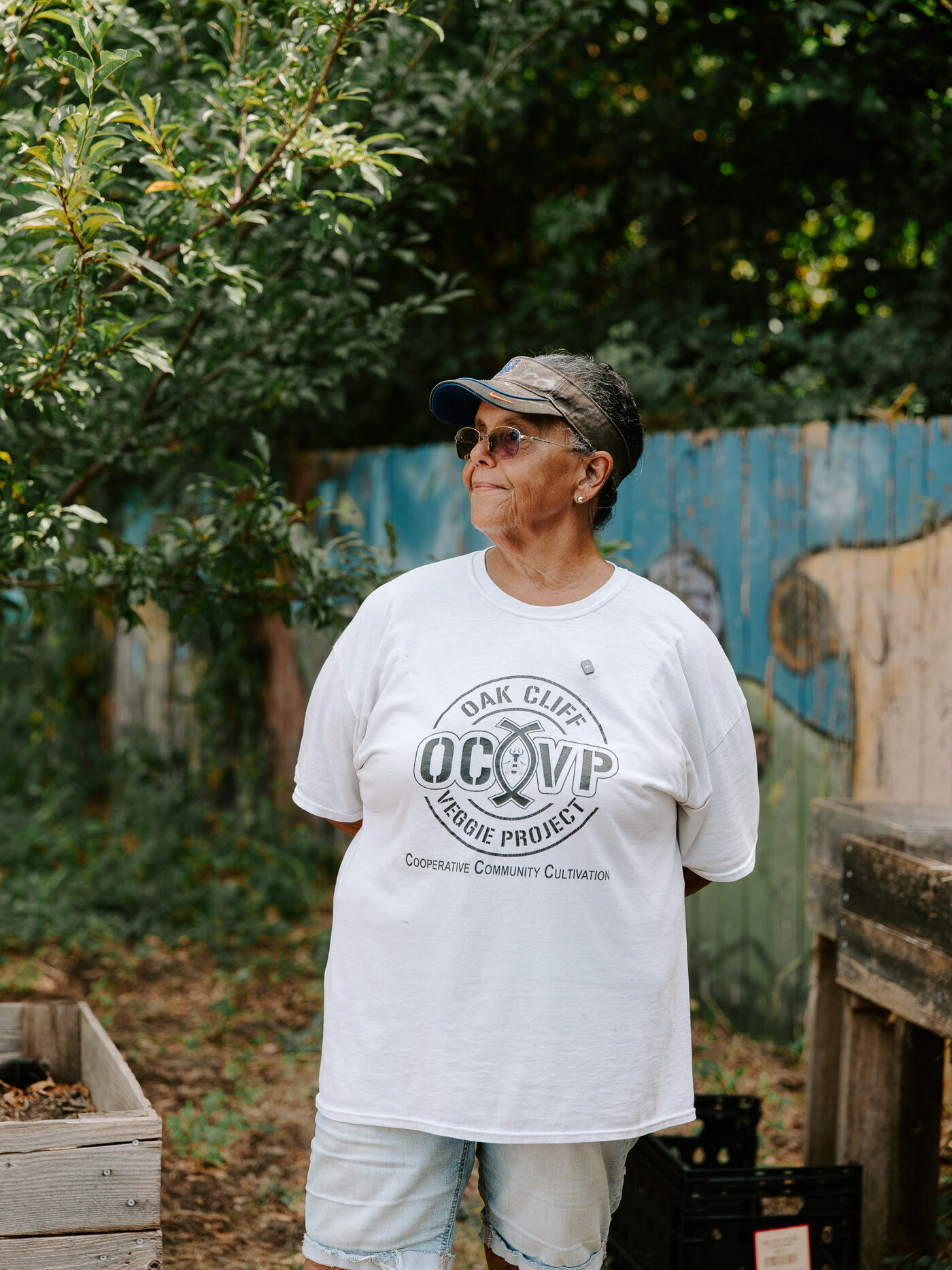 An Oak Cliff Veggie Project team member stands in the 10th Street Community Garden