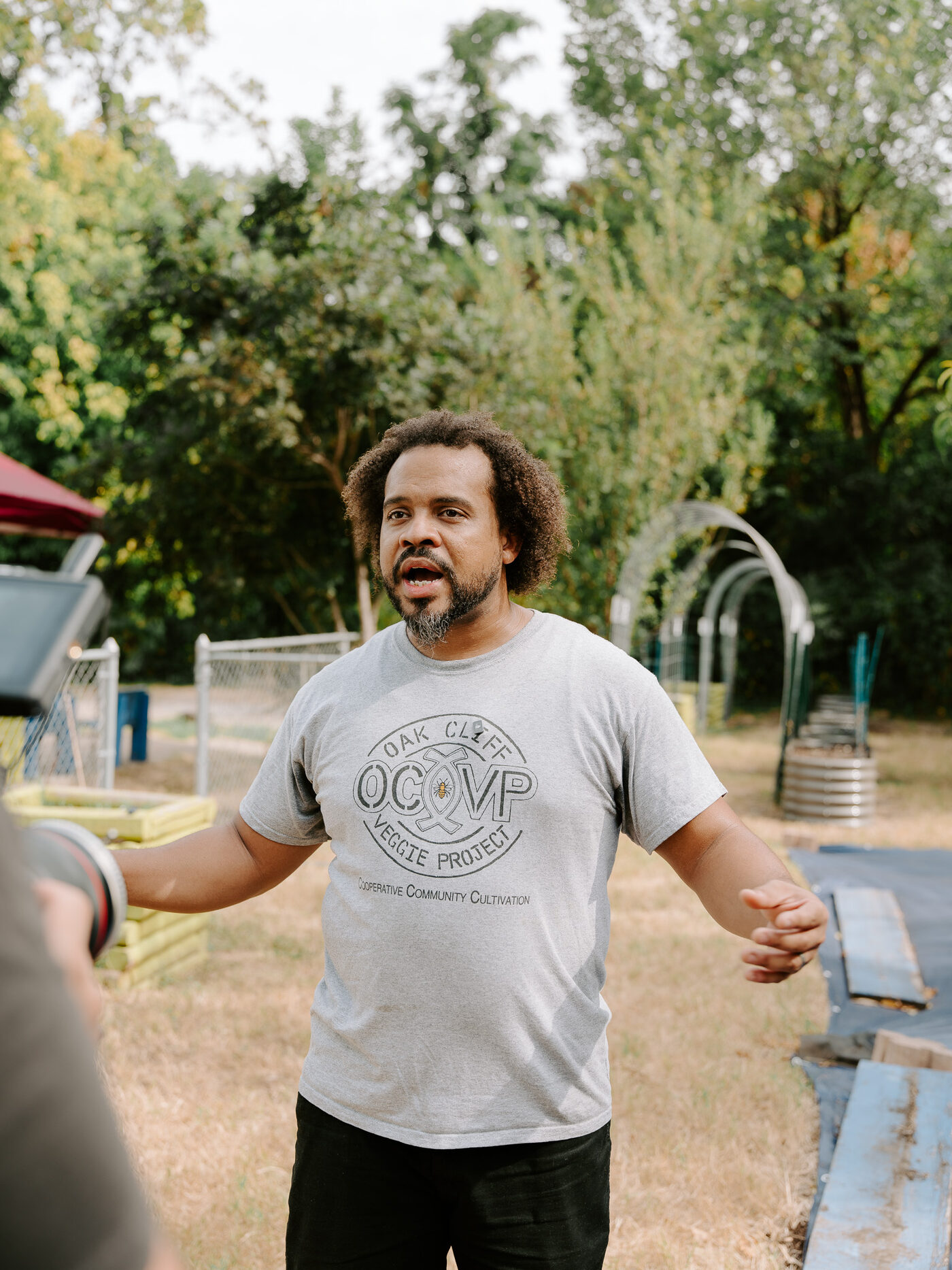 An Oak Cliff Veggie Project team member speaks during an interview at the 10th Street Community Garden