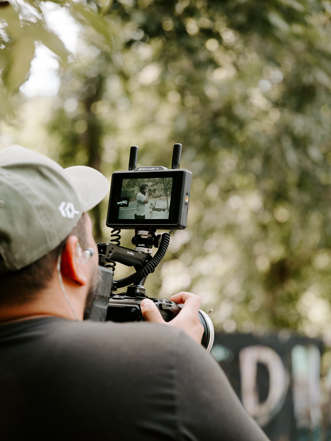 A cinema camera monitor framed on the garden during an interview setup