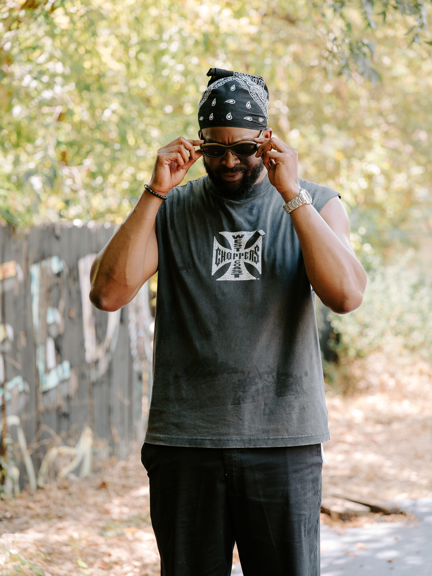 A volunteer adjusts his sunglasses between takes at the community garden
