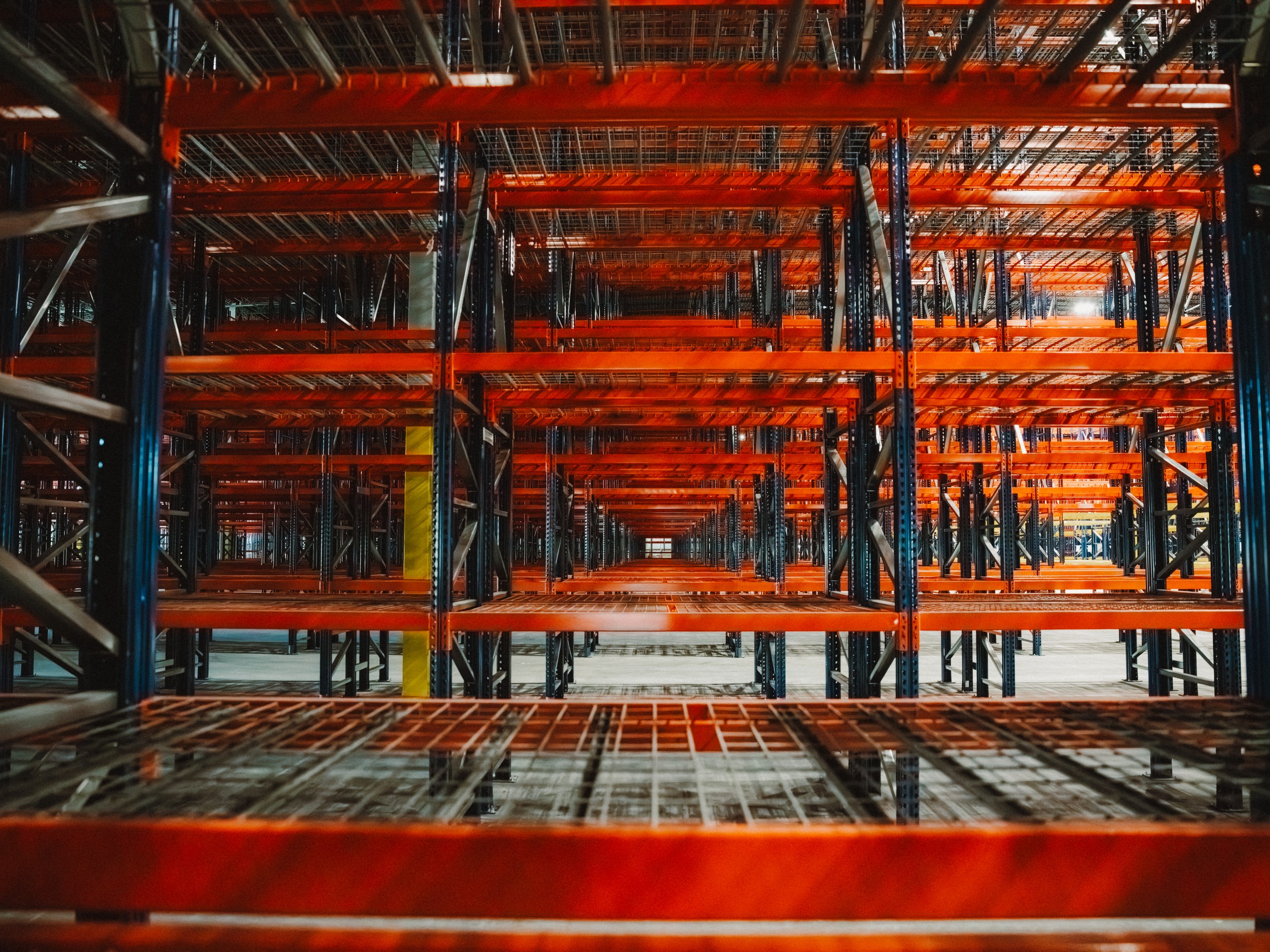 Racking beam levels photographed from below, showing wire decking and beam connections