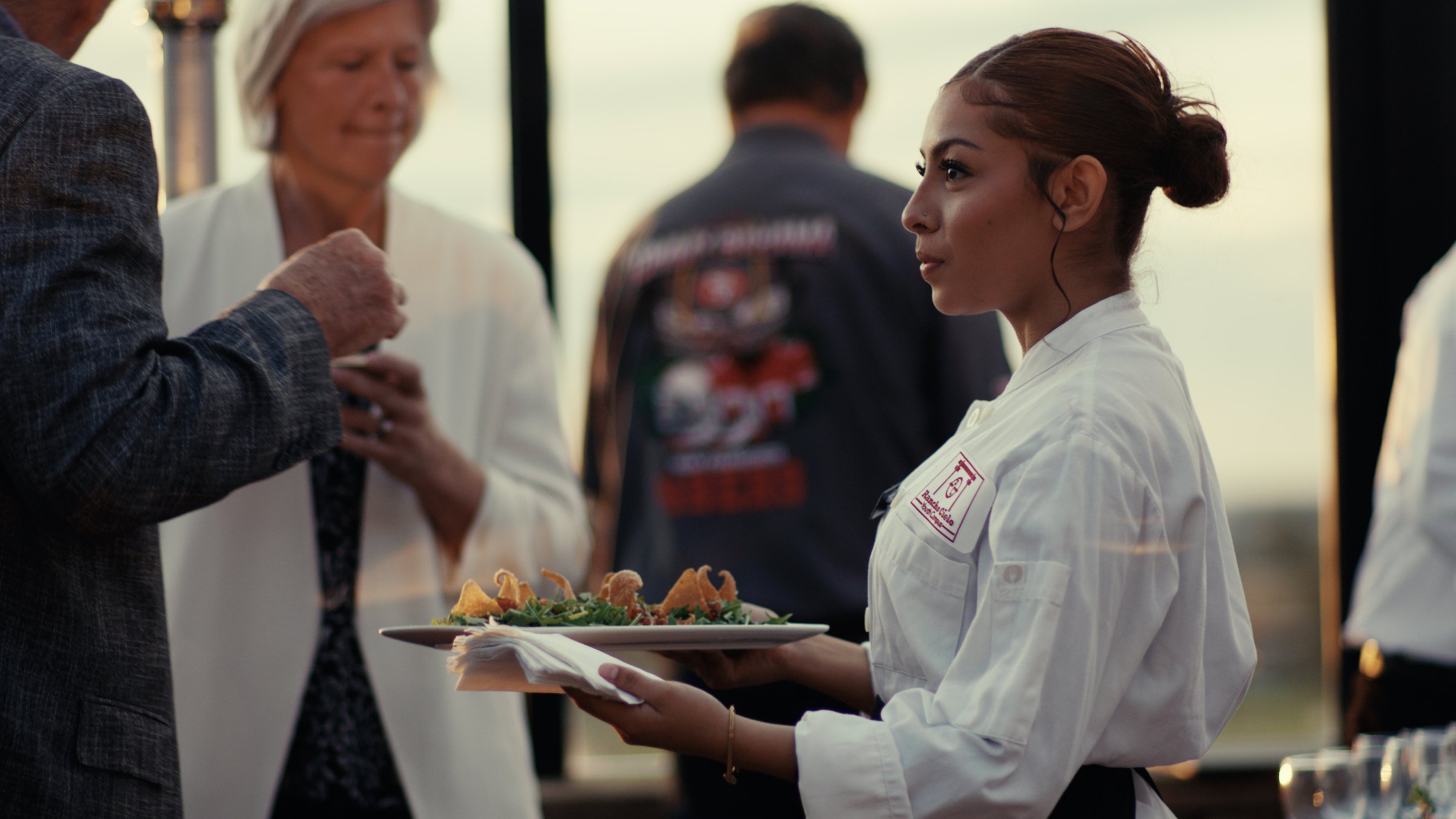 Chefs serving guests at a golden hour chapter reception