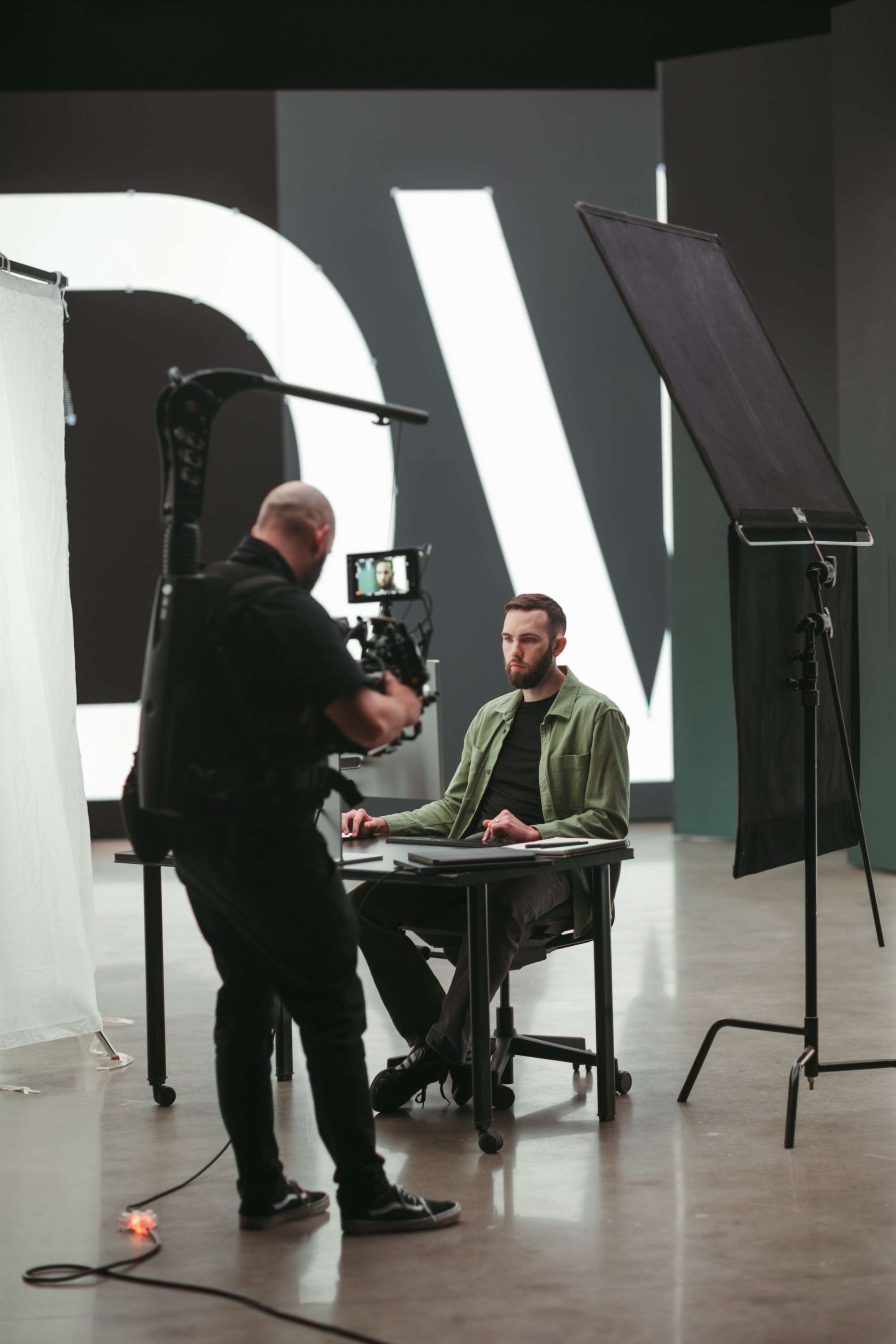 Steadicam operator filming a subject at a desk