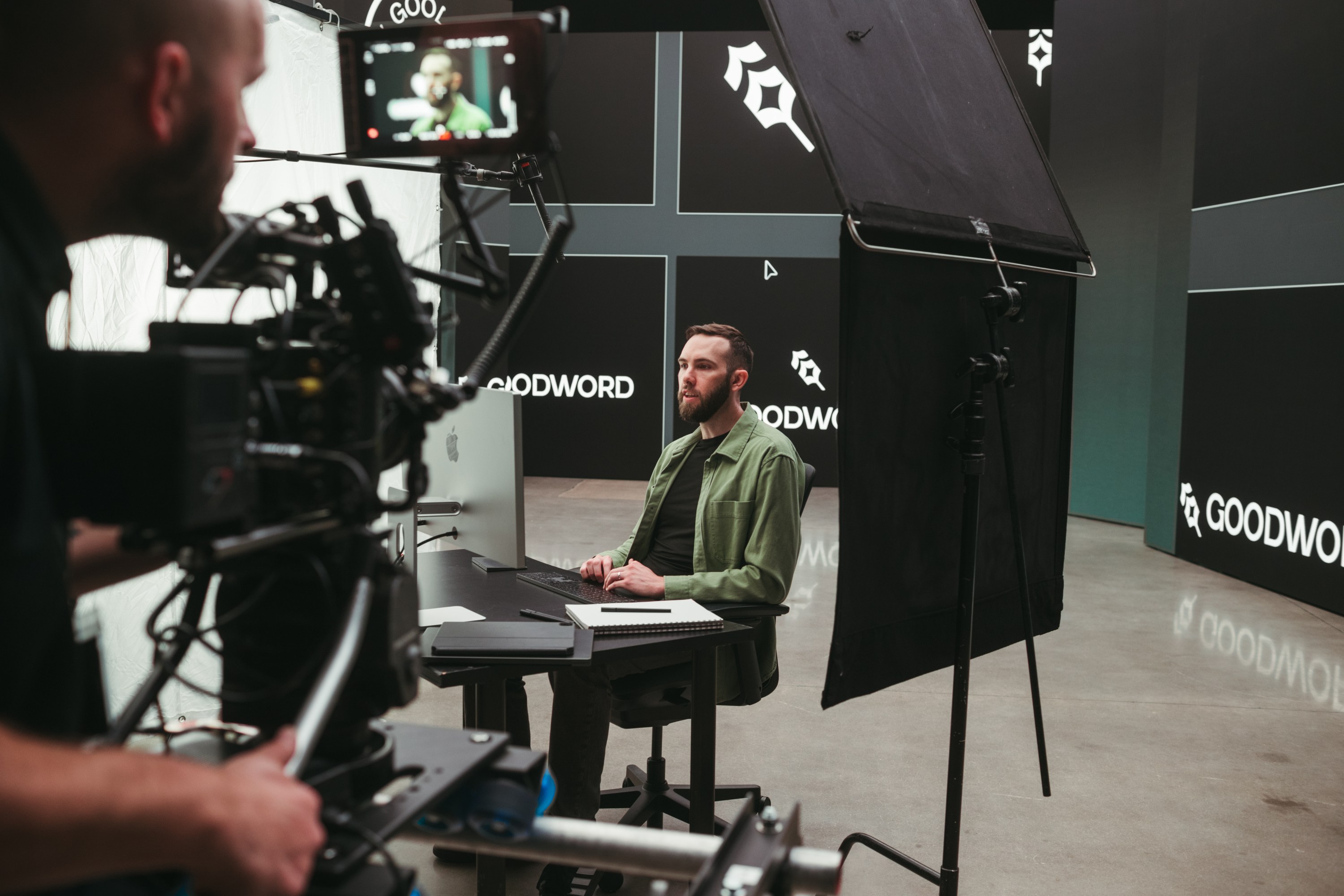 Camera operator filming a subject at a desk