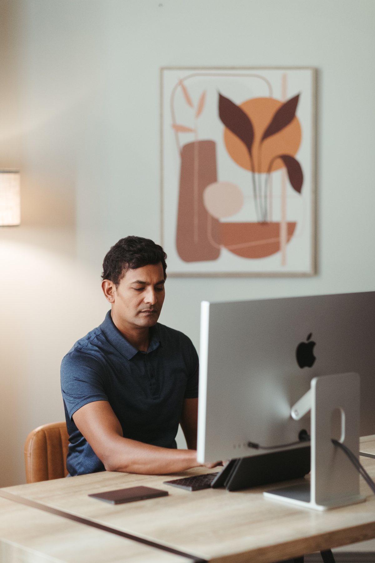Man working at a desktop computer in a bright office