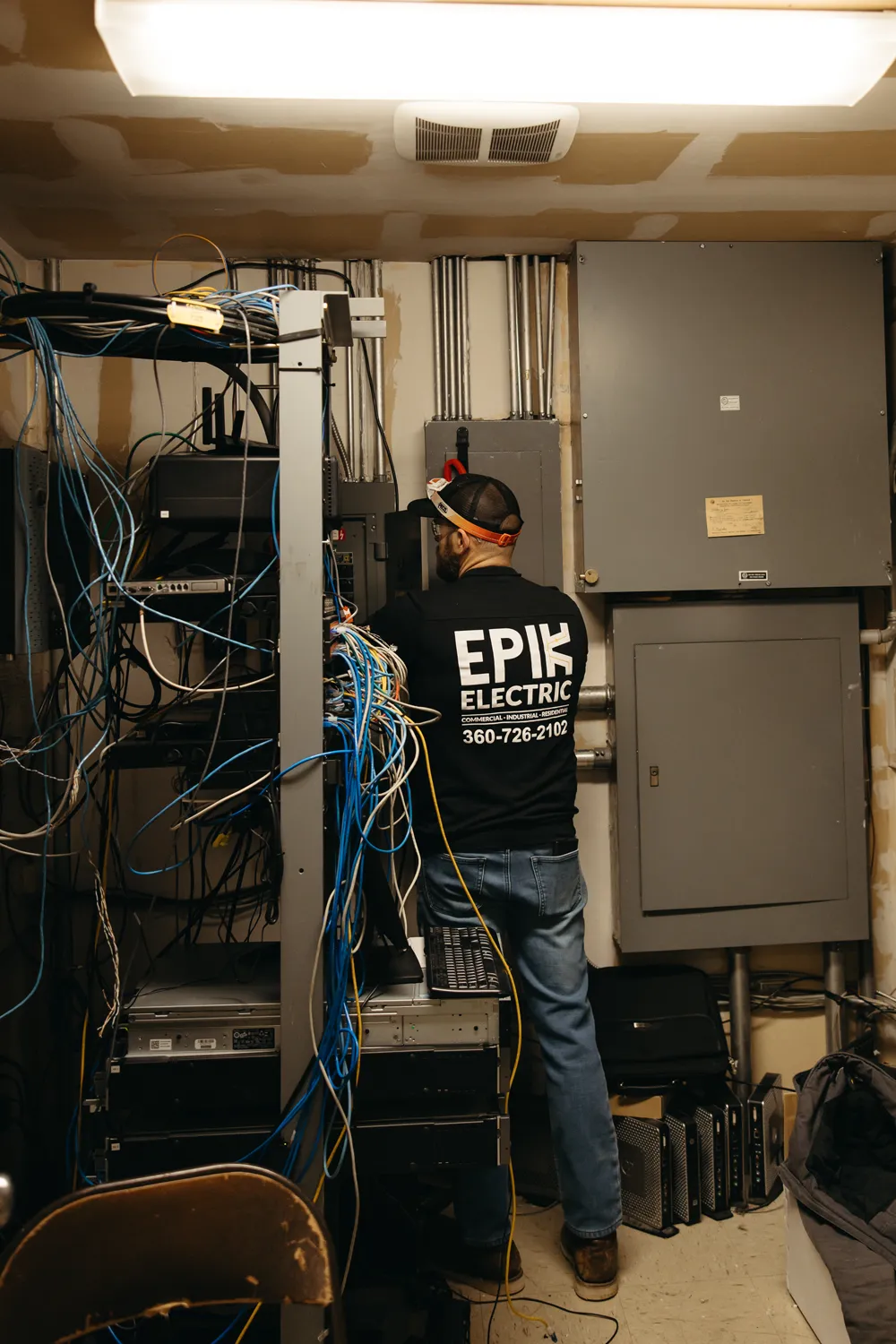 skagit county electrician jared freeman of epik electric working near an electrical panel in new commercial construction