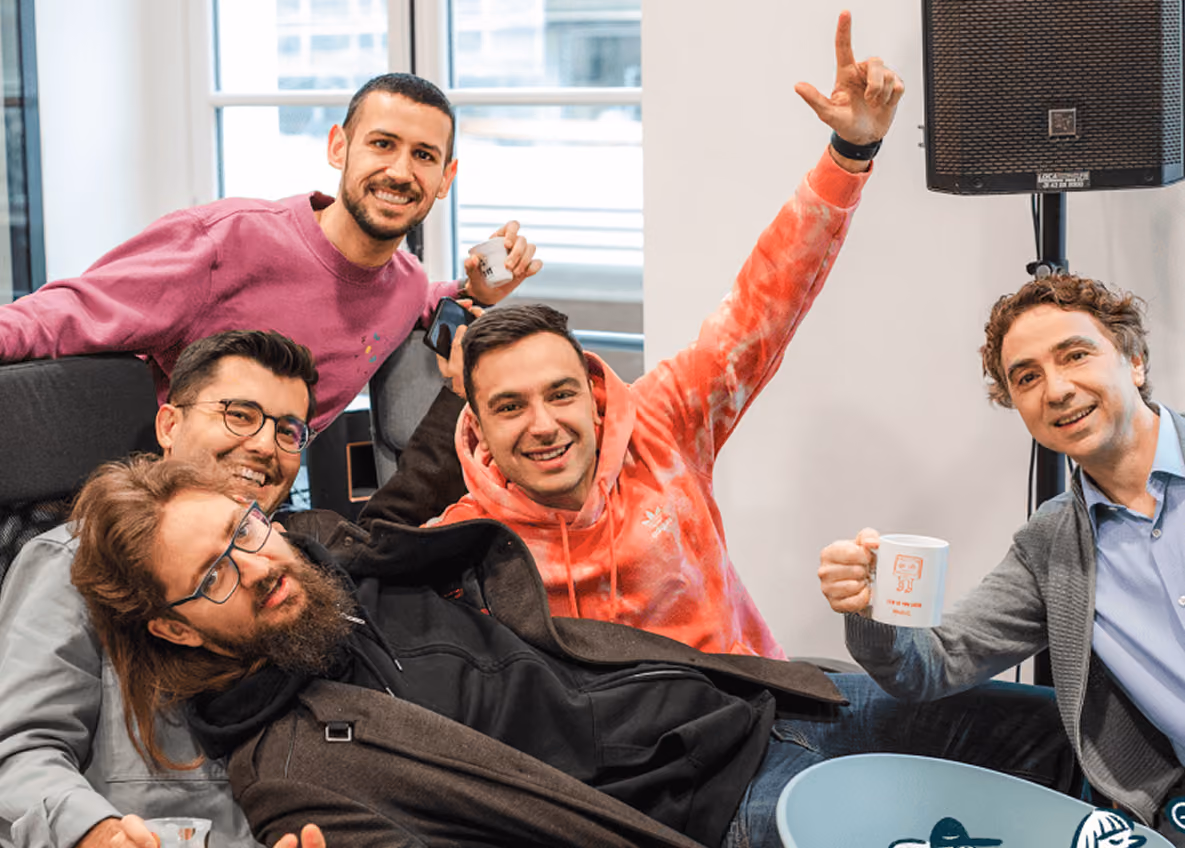 Group photo of Surfe team members smiling and celebrating together in an office.