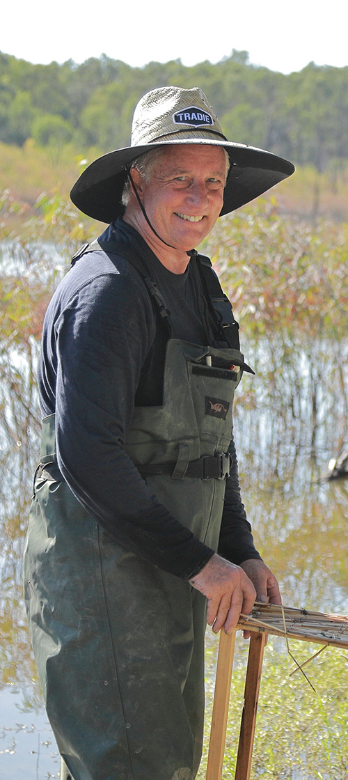 Freshwater ecology consultant conducting field research and aquatic monitoring in waders