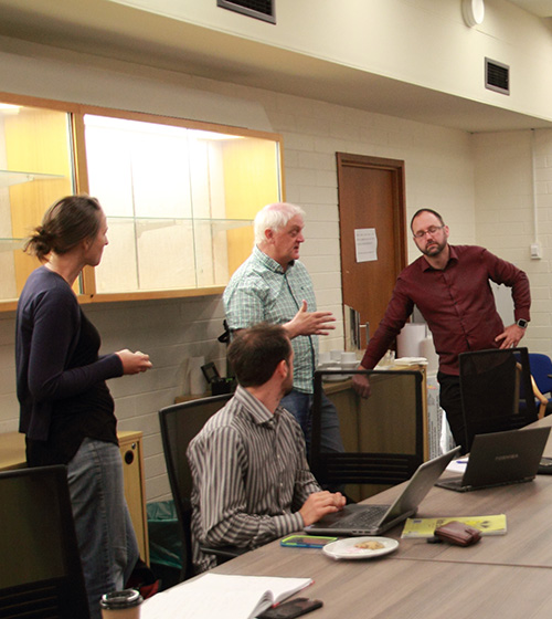 Group of environmental consultants collaborating in an office setting to analyze ecological data and conduct evidence-based assessments for Gyre & Gimble Consulting