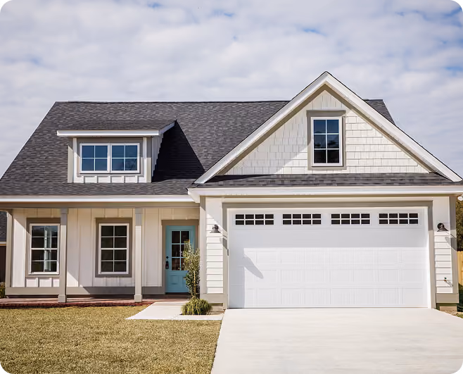 Modern two-story house with gray roof, white garage door, front yard, and turquoise front door.