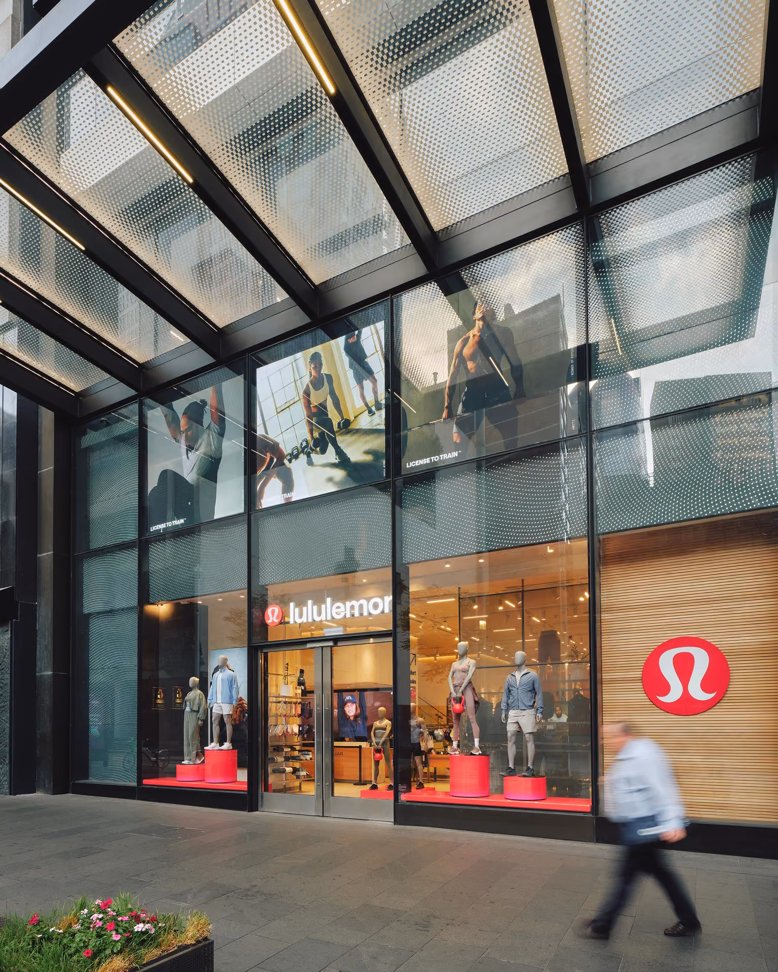 Lululemon store front with mannequins wearing athletic wear and large logo on window.