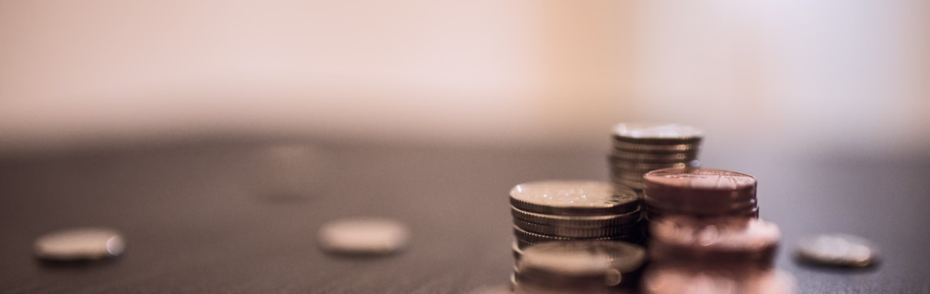 Close-up of stacked silver and copper coins on a dark surface with a soft background.