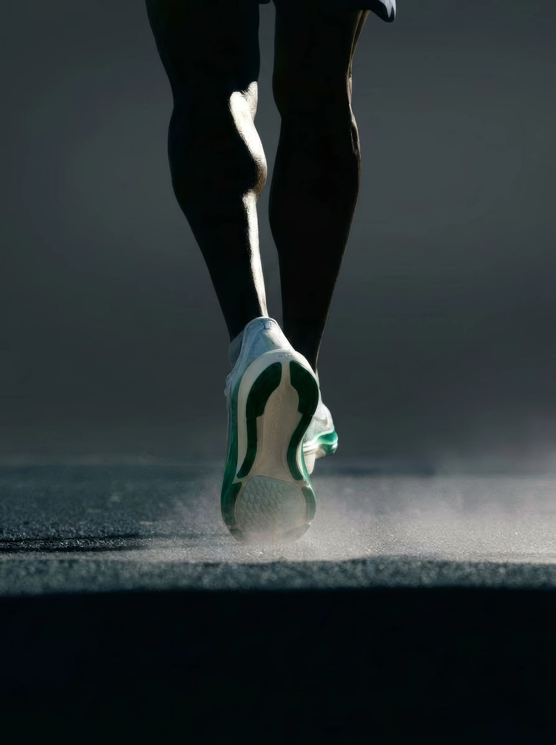Runner's legs mid-stride on a dark road