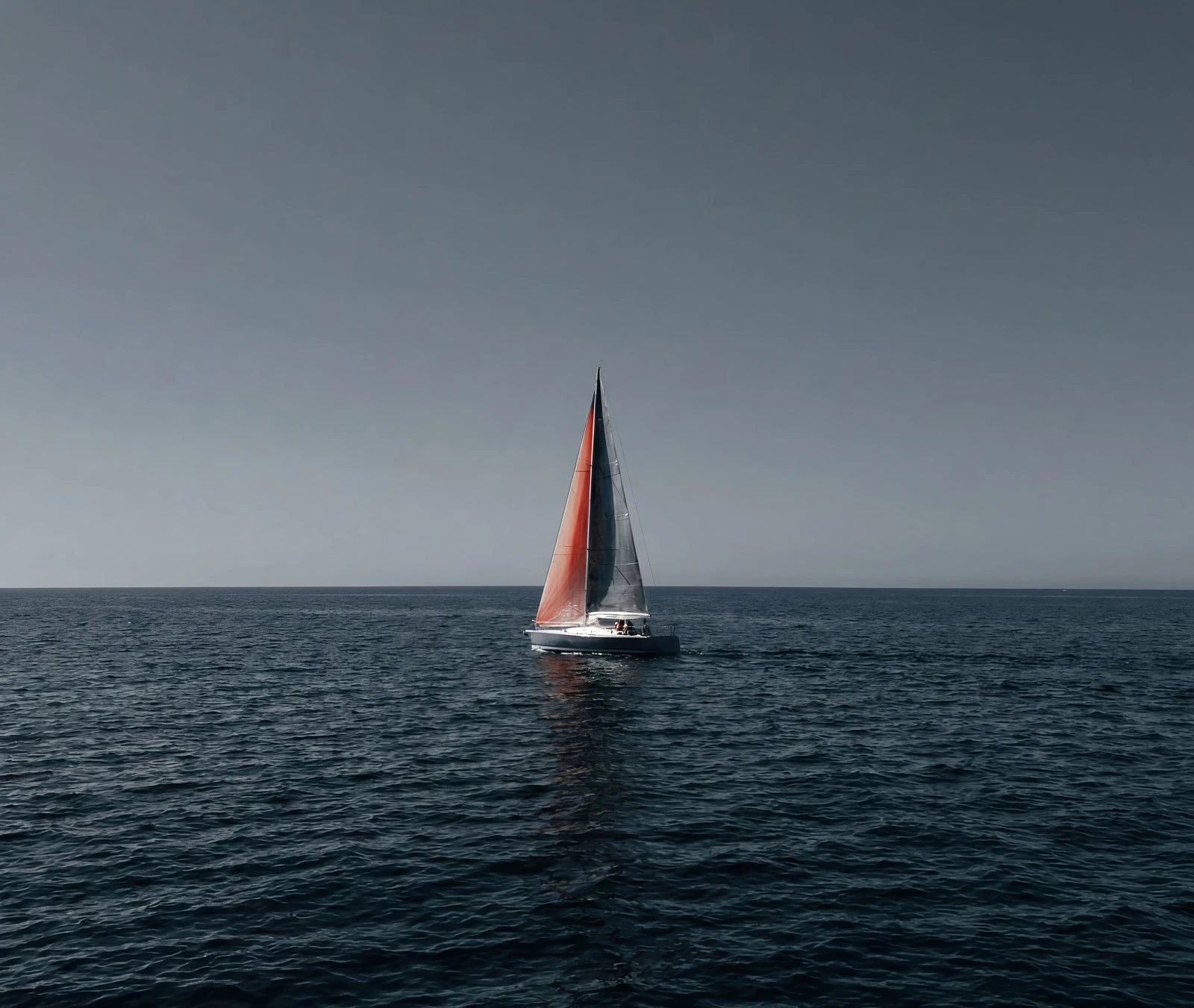 A single sailboat on a dark open sea