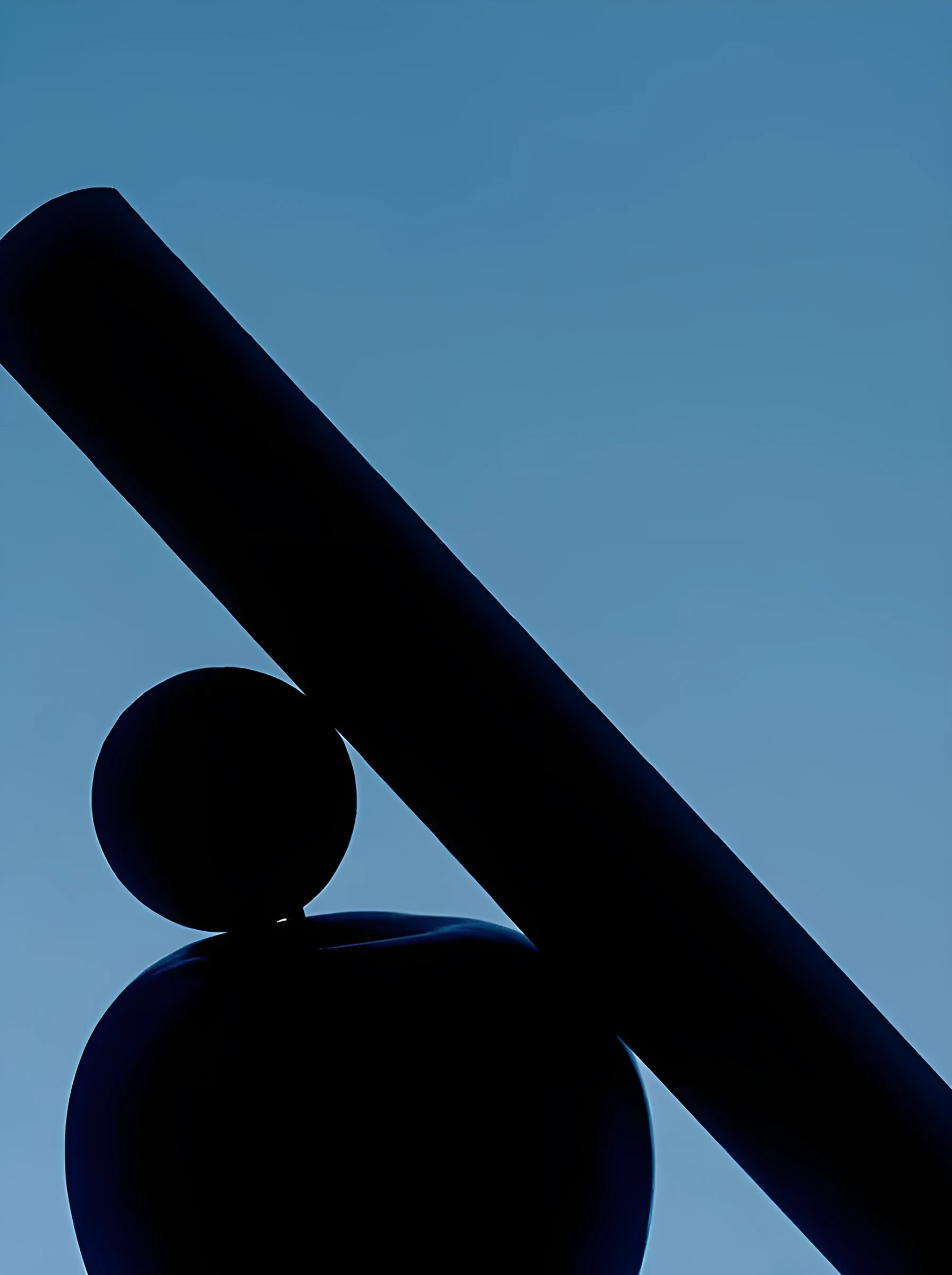 Dark bar balanced on a sphere against blue