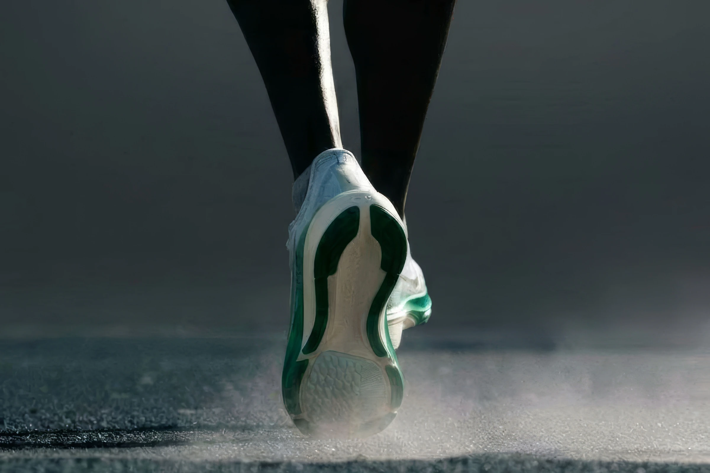 A runner's foot striking the ground mid-stride
