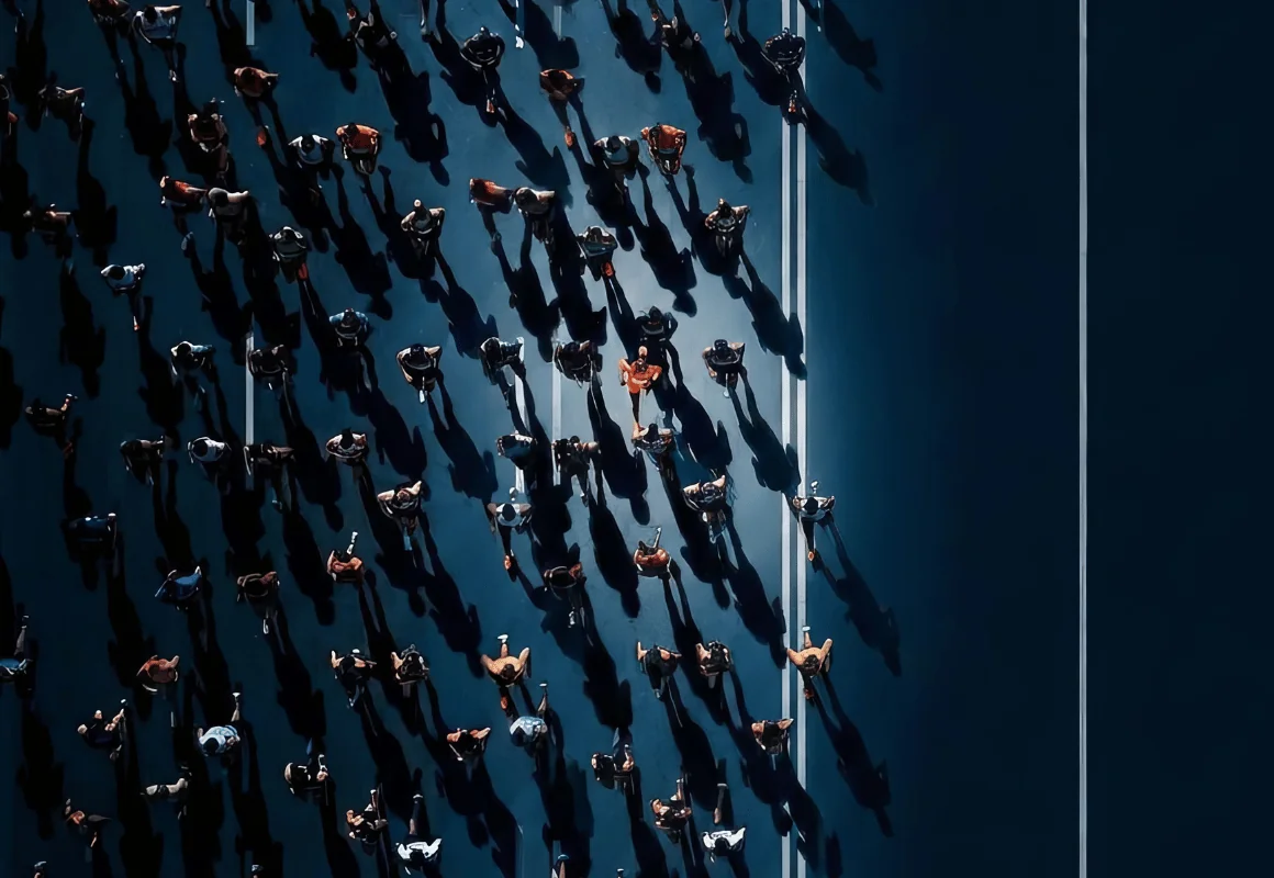 Aerial view of a crowd of people walking across dark ground