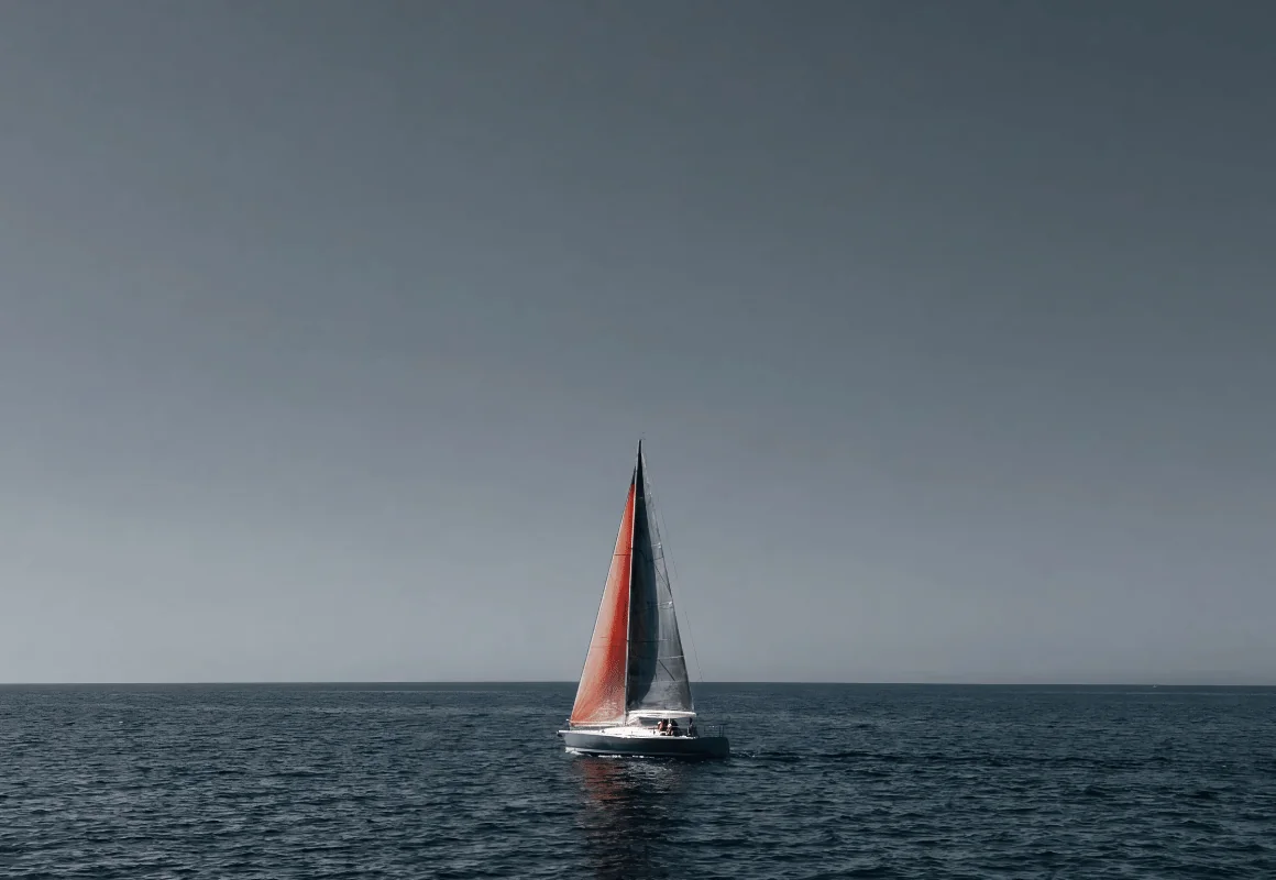 A single sailboat on a grey sea