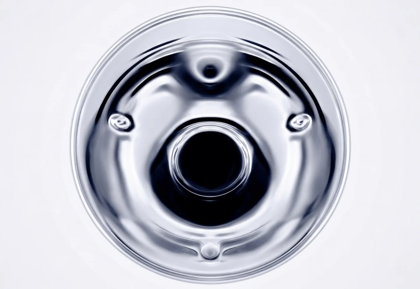 Polished chrome aperture on a pale background