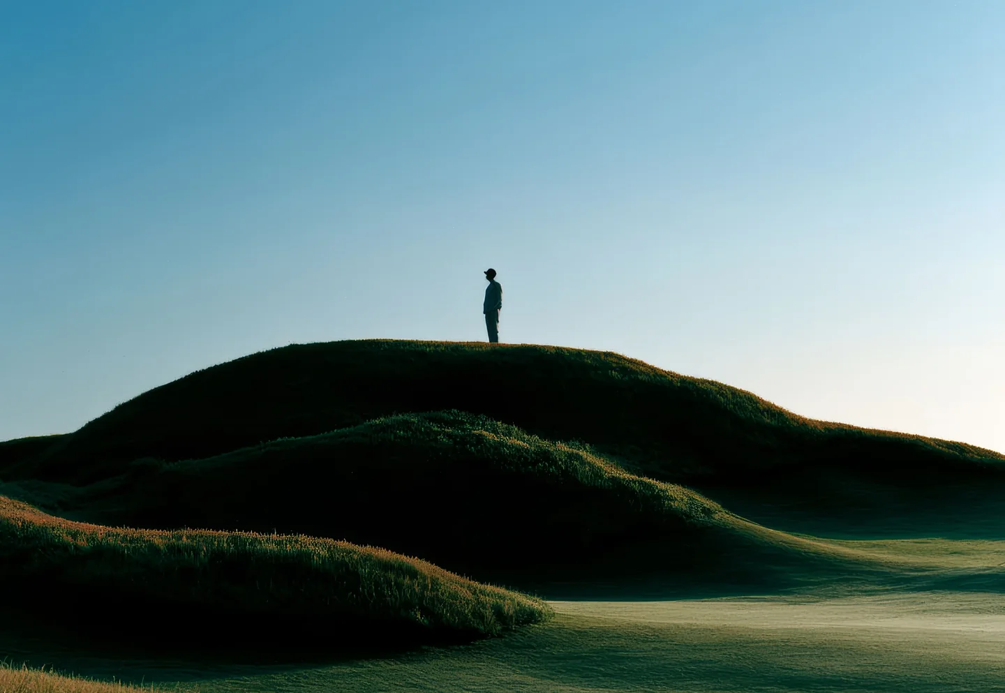 A lone figure standing in an open field