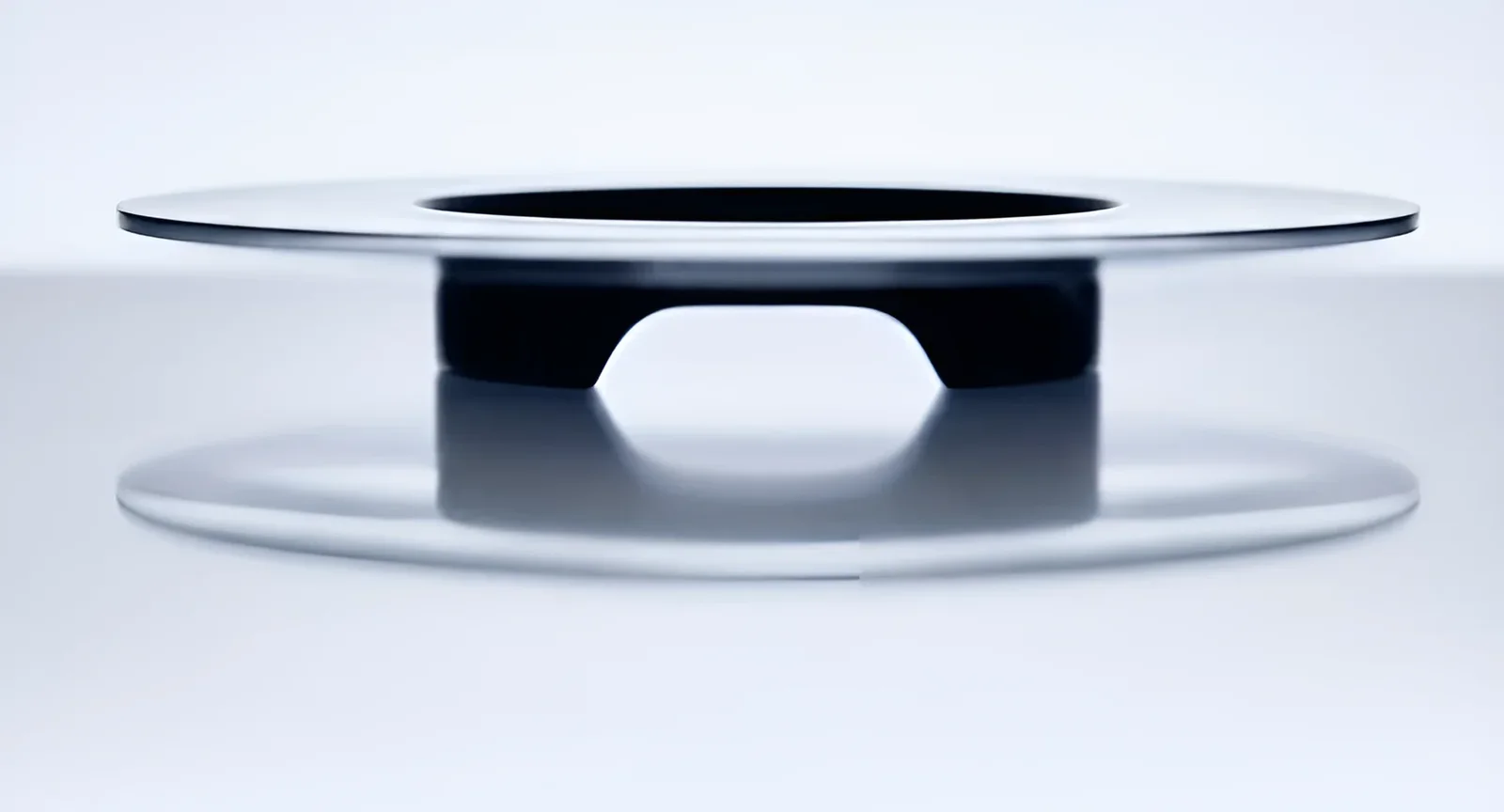 A floating machined disc on a pale background
