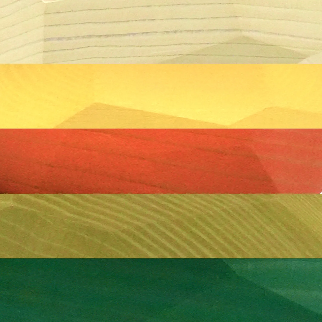 Close-up of stacked tumi-isi wooden blocks in cream, yellow, red, and green bands