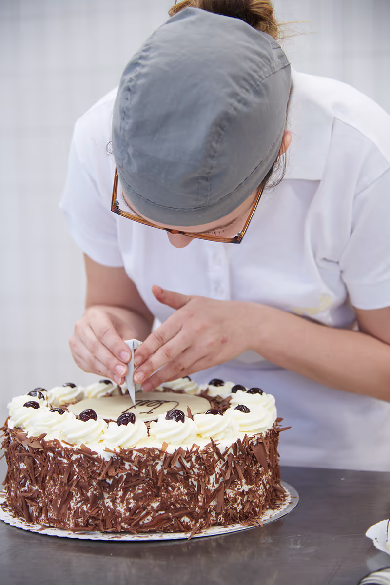 Konditorin bestückt eine Torte.