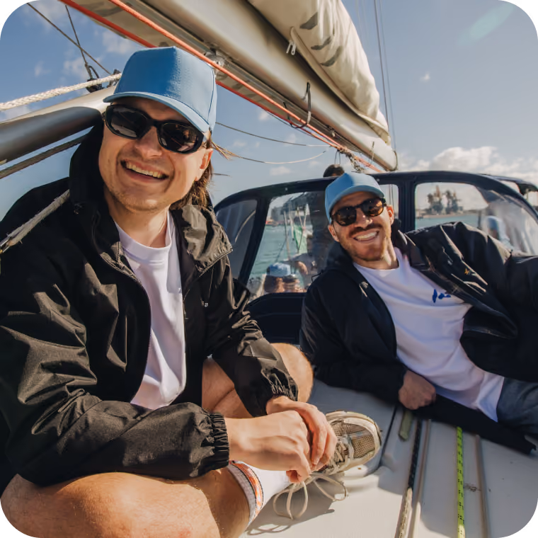 Two Almedia employees on a boat smiling at the camera