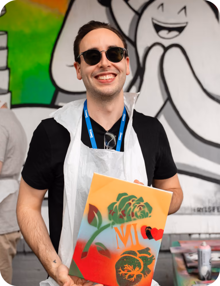 Almedia employee in an art workshop holding his art piece