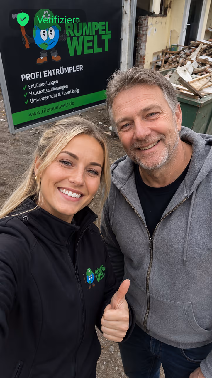 Smiling man and woman outdoors by a Rümpelwelt sign; woman gives thumbs up wearing branded black jacket.