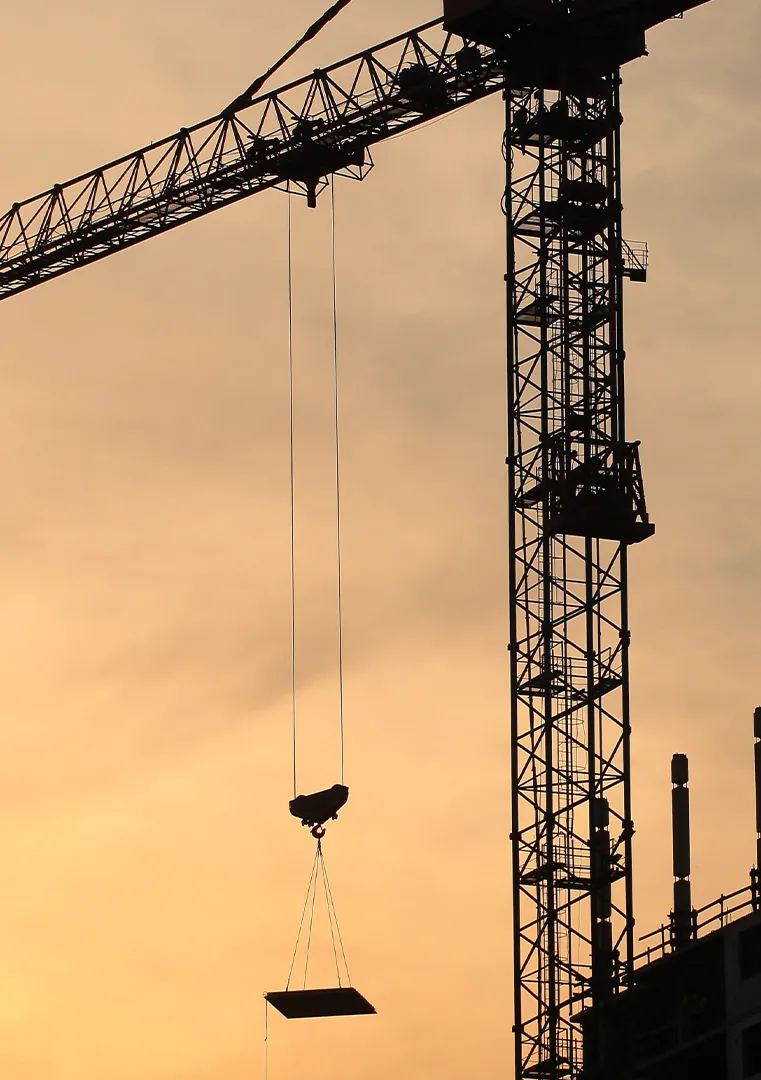 Gru a torre in un cantiere edile durante le operazioni di sollevamento dei materiali da costruzione.