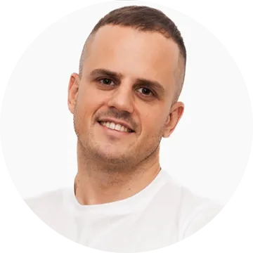 Smiling man with short hair wearing a white shirt against a white background.