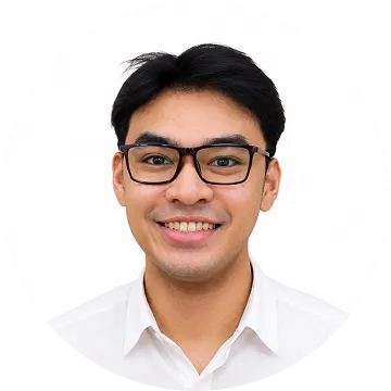 Smiling young man with glasses and black hair wearing a white collared shirt on a white background.