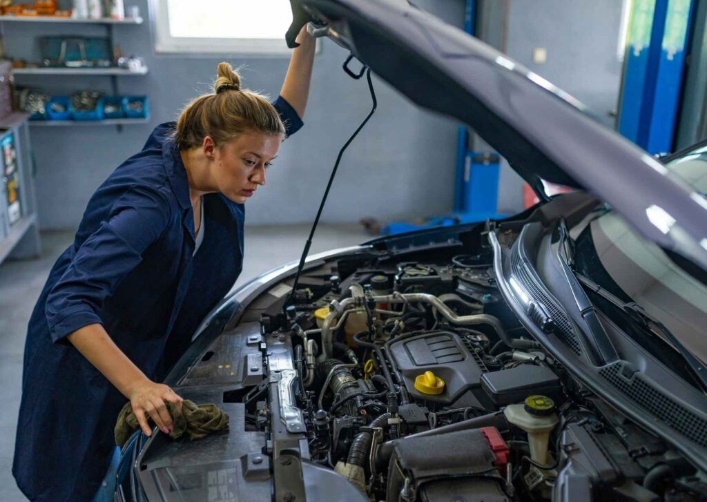 Junge Frau betreibt Fahrzeugwartung.