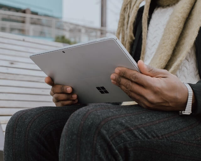 Sitzender Mann hält Tablet.