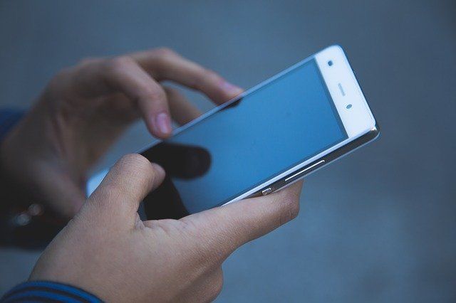 Ein Smartphone wird in den Händen gehalten.
