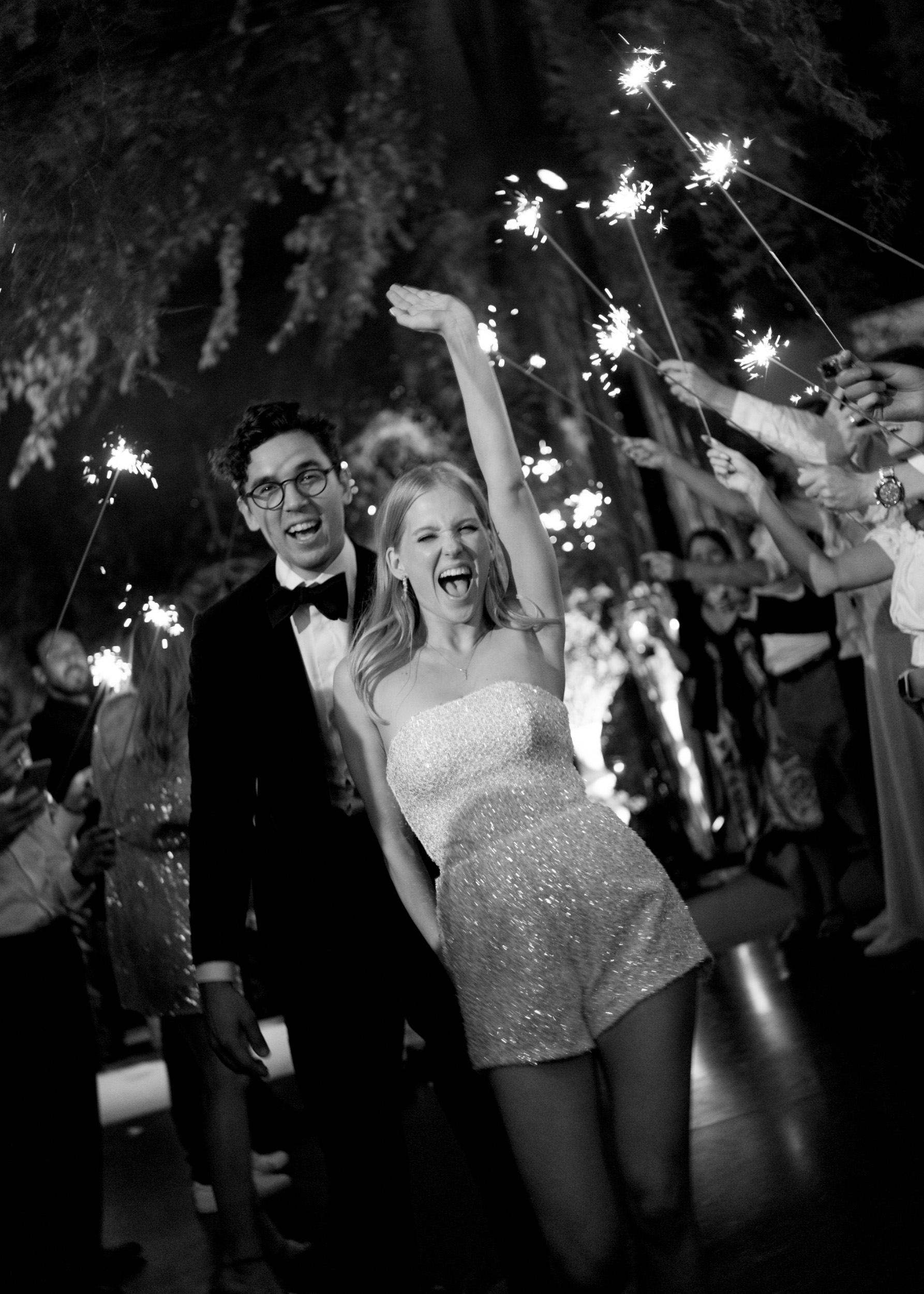 Black and white photo of a couple embracing closely, the woman with eyes closed and arms around the man.