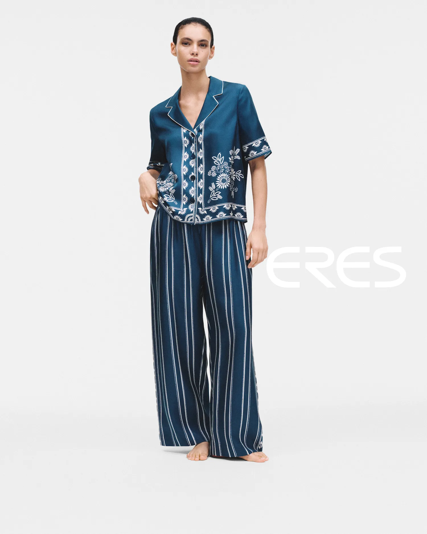 Model wearing a blue floral patterned short-sleeve top and matching wide-leg striped pants.