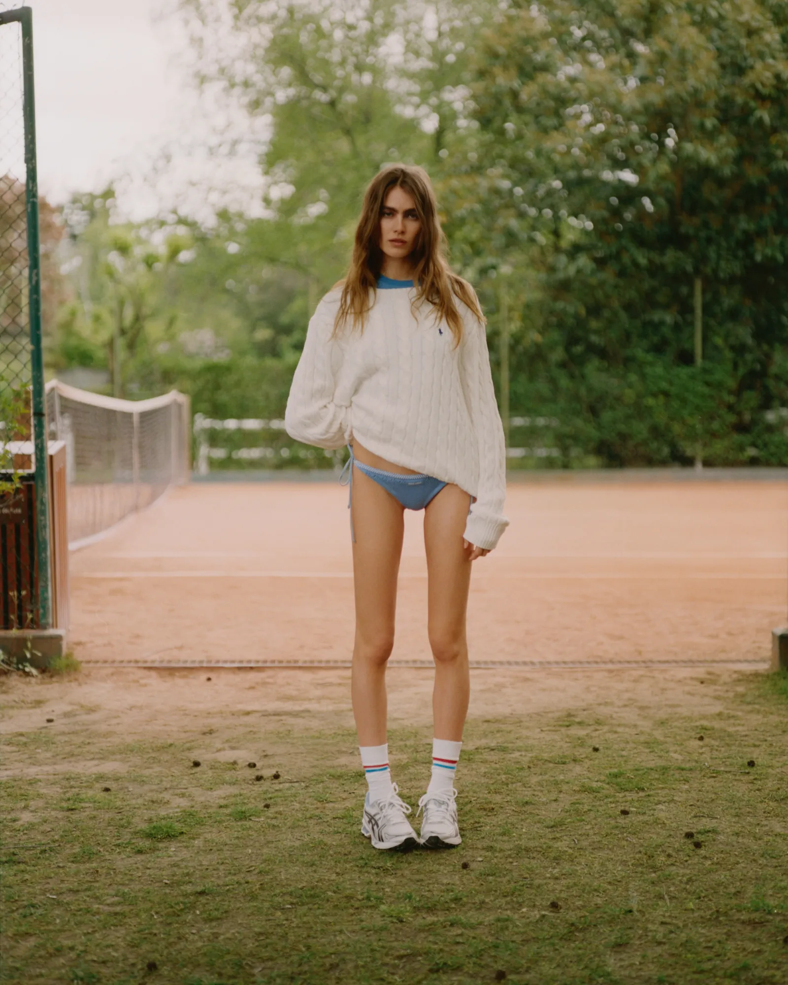 Pair of brown leather sneakers with white soles on a wooden surface.