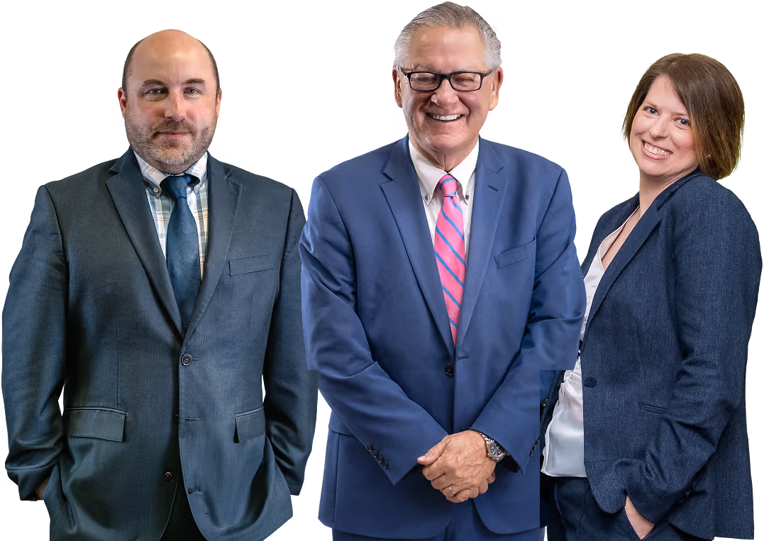 Three business professionals in suits smiling and posing against a white background.