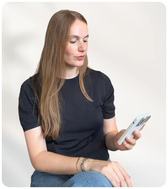 MindClub-Expertin betrachtet ein Smartphone