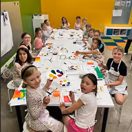 Kids holding up vibrant tie-dye art projects