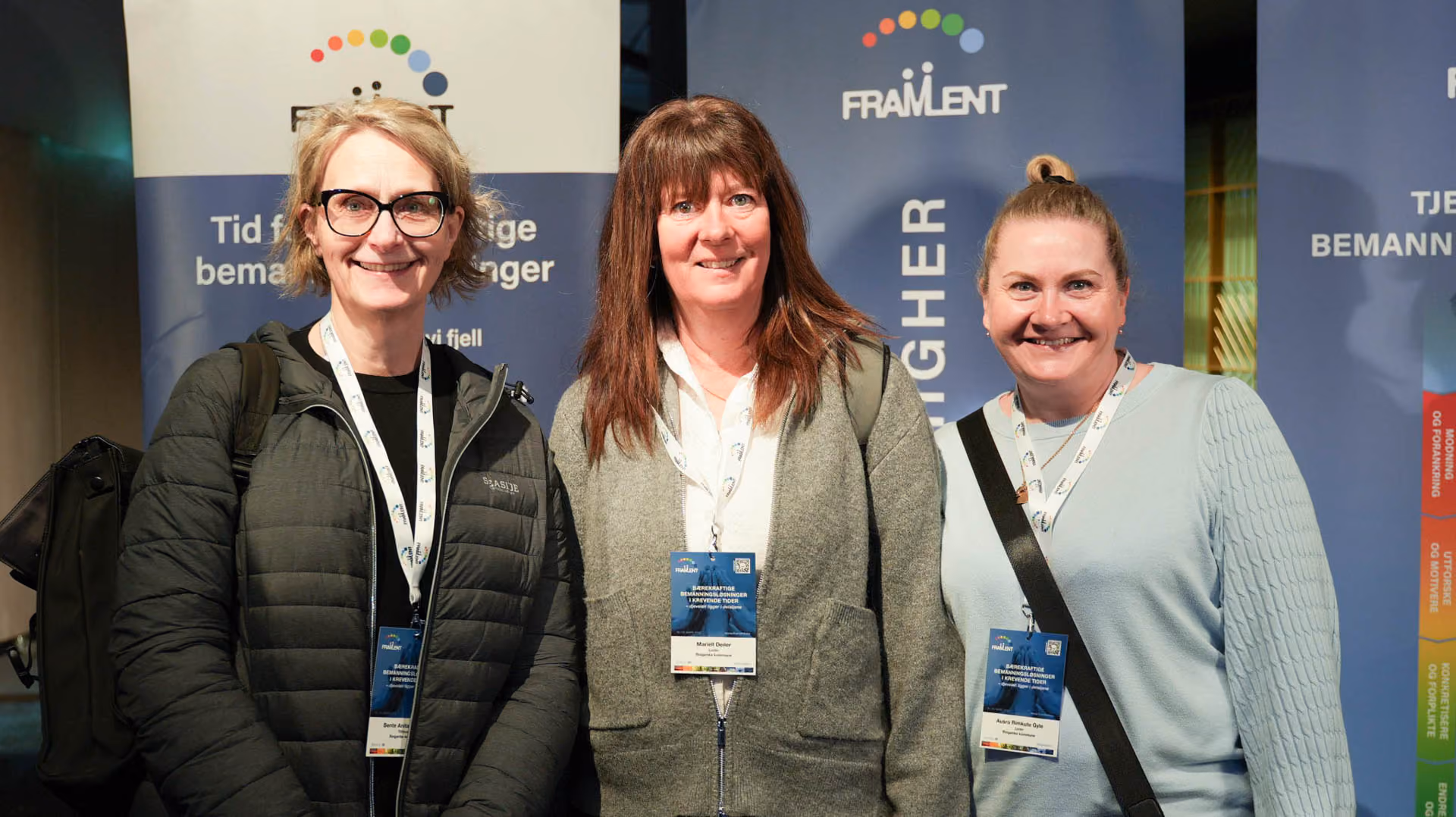 Tre smilende kvinner med navneskilt står foran blå FRAMLENT-gradient bakgrunnsvegger.