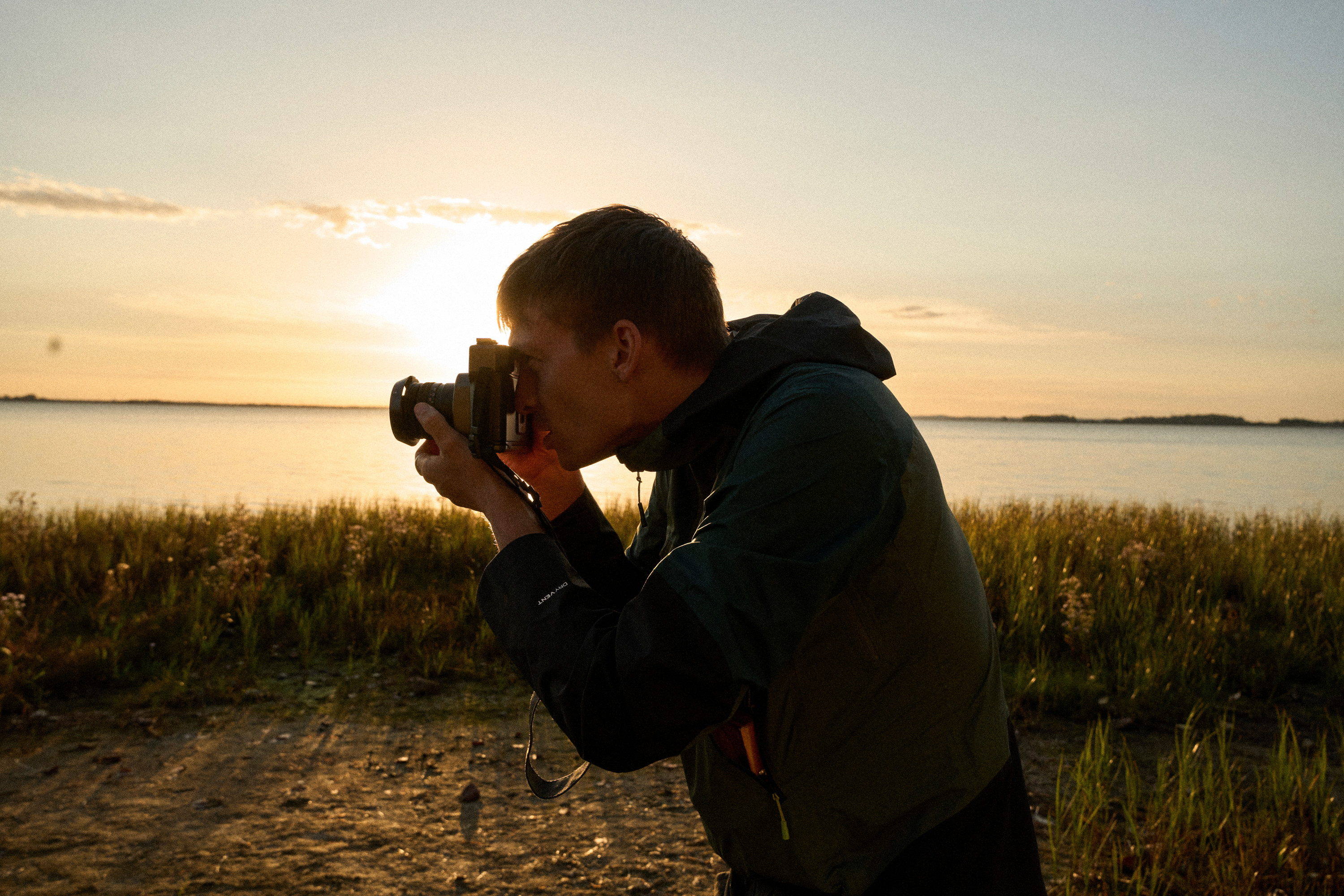 Felix Reimers photographing beside the sea in the last light of the day.