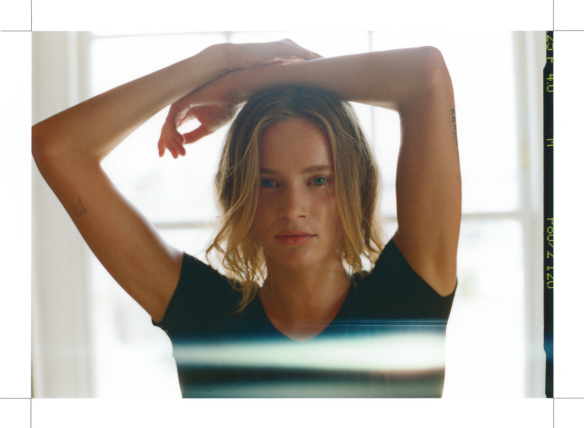 DESCENTE Athletic Originals: Dancer in a black top with arms raised beside a bright studio window.