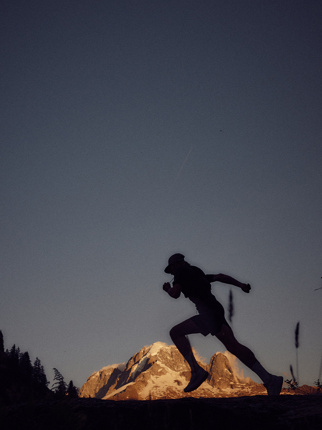 Arc'teryx Translating Flow State: Trail runner silhouetted against an illuminated mountain peak.